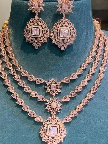 A beautiful rose-gold plated Victorian set with three layers and intricate floral-inspired designs. This is a delicate and elegant choice for any modern event.