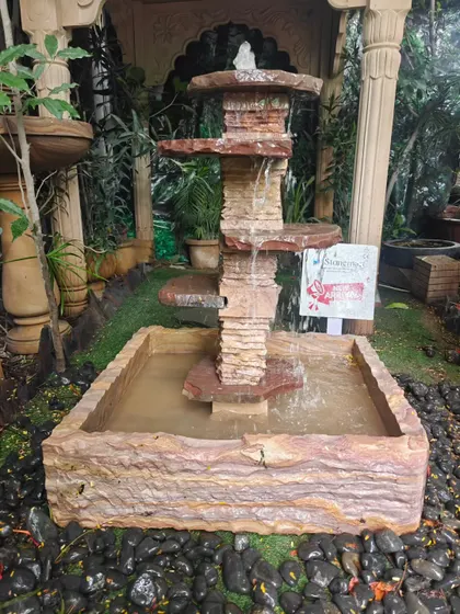 Another view of the cascading natural stone fountain, showing the water flowing between the tiers.