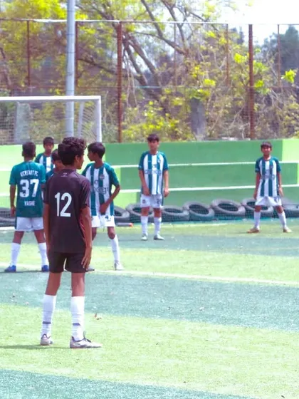 The calm before the kick. A U-13 player focuses before taking a crucial set-piece in a competitive match.
