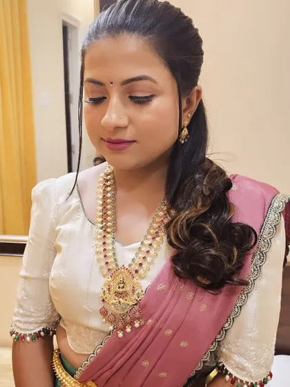A soft and pretty look for a client. The makeup is natural, and the hair is styled in a simple, wavy ponytail.