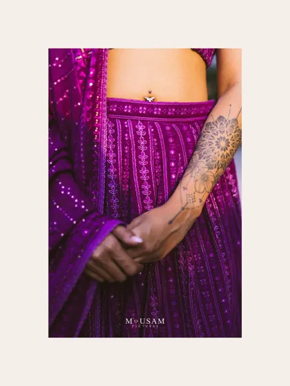 A detail shot focusing on the bride's modern mehendi attire and her unique tattoo. It’s these personal touches that tell a deeper story about who she is, blending tradition with individual style.
