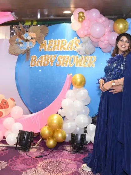 A wide shot showing the happy couple in front of their moon-themed baby shower backdrop. I always capture the full setup to remember all the details of your special day.