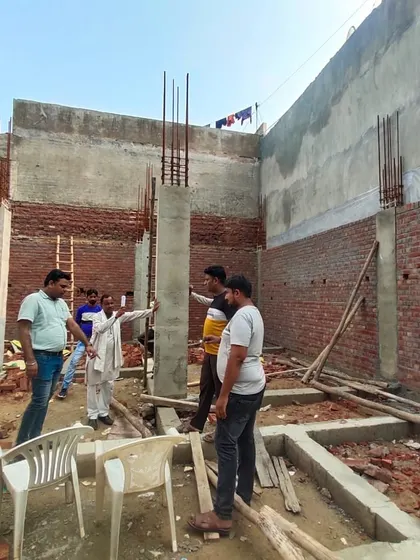 Discussing the structural layout with the team on the residential construction site.