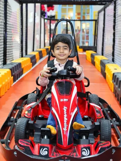 This happy racer is buckled up and ready for a safe and exciting drive in one of our red electric karts.