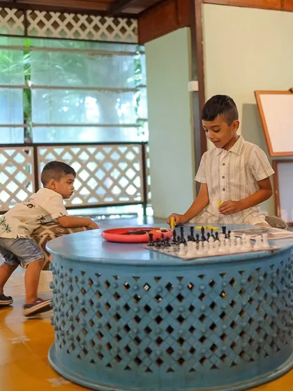 Two young boys are deep in concentration over a game of chess, showing that our game spaces are welcoming for all ages.
