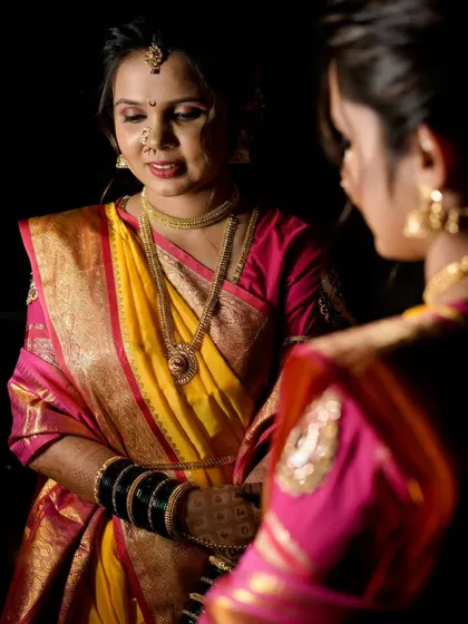 A soft, reflective pose of the bride looking in the mirror, capturing the quiet moments before the wedding ceremony begins.