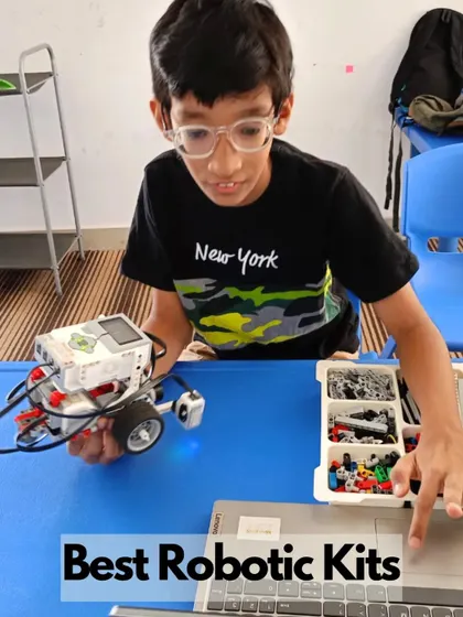 A student programs his advanced robot using a laptop, demonstrating the progression to more complex coding languages.