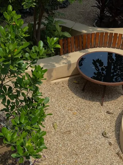 **Playfold, Ahmedabad:** An overhead view of a seating nook created by the curving bench. The design carves out intimate spaces for conversation and relaxation, surrounded by lush greenery.