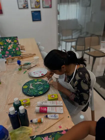 Another artist at work, adding the final touches to her Koi Fish scene. The vibrant colors and delicate details are coming together beautifully.