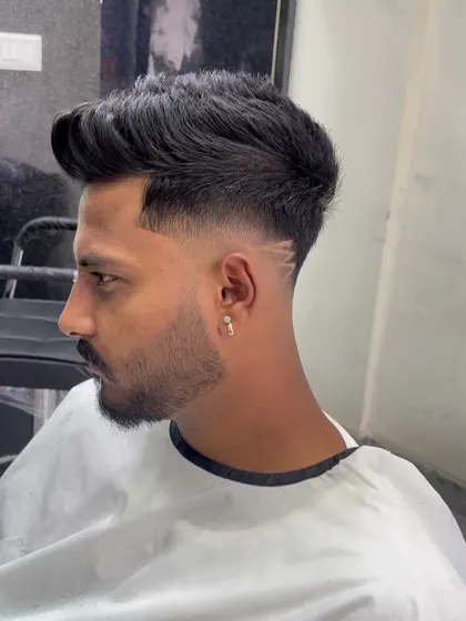 This haircut features a mid-fade with a creative line design carved in. It's a great way to add a personal touch to a classic fade.