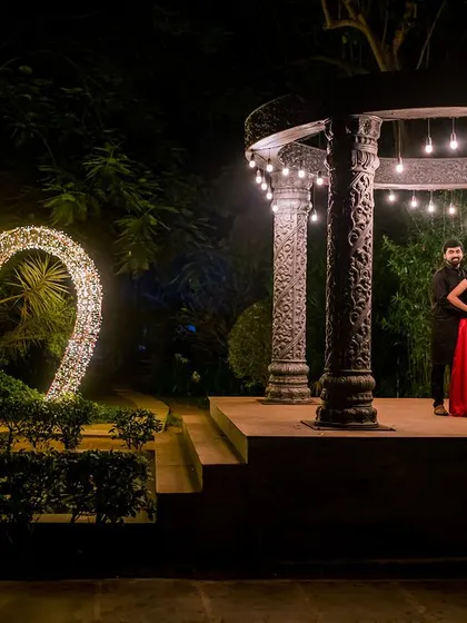 A wide shot capturing the beautiful night scenery at Elements Celebrate. The illuminated heart and the lit-up stone structure create a magical backdrop for the couple.