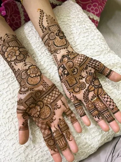 A beautiful and full party mehndi design covering both hands. This style combines floral elements, geometric grids, and traditional paisleys, making it perfect for a close family member at a wedding.