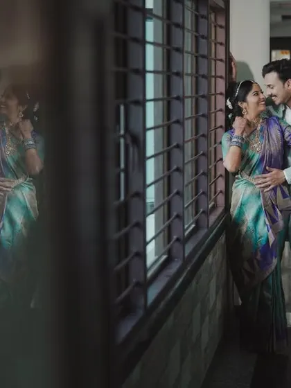 A creative shot using reflections to capture a romantic moment between the couple during their Varapooje.