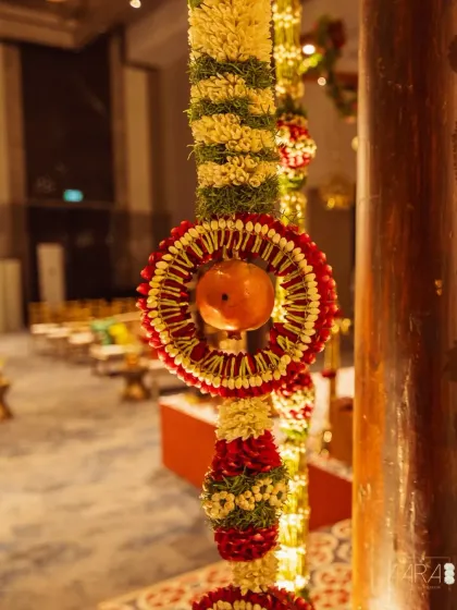 A close-up of the handcrafted floral garlands used in our 'Divya Stambh' theme. These intricate details, combining jasmine, roses, and sacred fruits, are a testament to the artistry of traditional South Indian decor.
