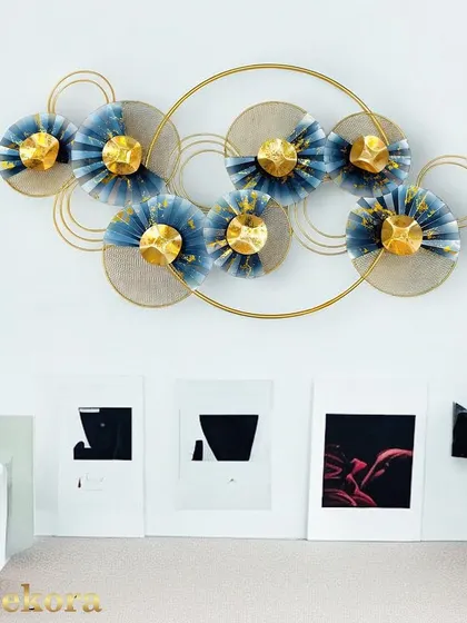 This modern wall sculpture features an arrangement of blue and gold fan-like shapes within a circular frame, creating a sense of harmony and movement.