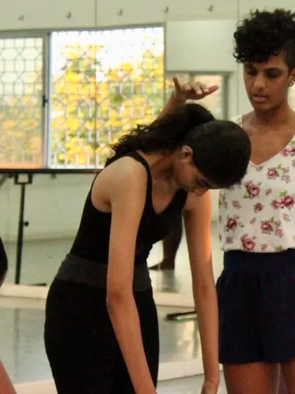 An instructor provides a gentle correction during a contemporary class. This individual attention helps students refine their posture and technique safely and effectively.