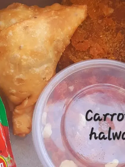 This adult snack box is perfect for any event. It contains two crispy samosas, a veg cutlet, a pot of homemade carrot halwa, and a ketchup sachet.
