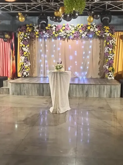 The stage is set! A beautiful setup with floral decorations and a wedding cake, waiting for the celebration to begin.