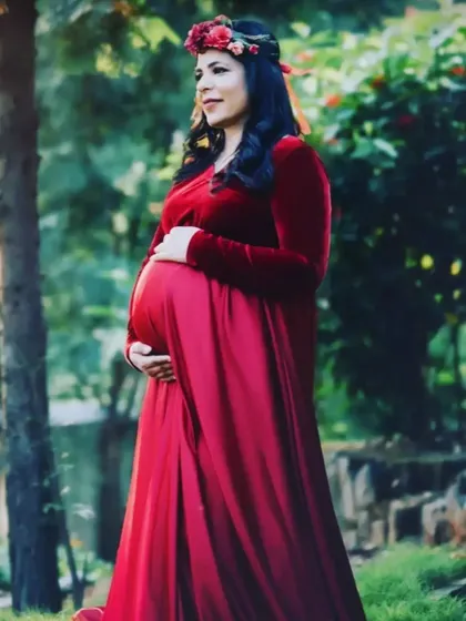 The best thing about this red velvet gown is its stretchable fabric, which comfortably fits various body shapes and sizes throughout pregnancy.