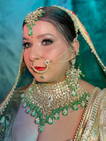 A full-face view of this stunning bridal makeup. The eyes are defined with a classic wing, and the red lip adds a touch of traditional glamour.