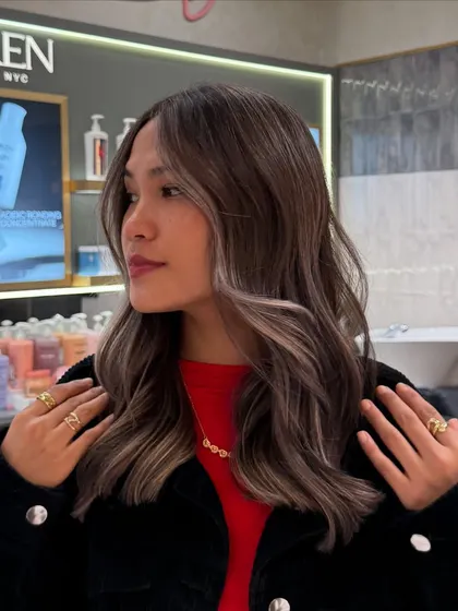 A client selfie showcasing her new signature balayage. The face-framing pieces brighten her complexion, while the overall color adds richness and dimension.