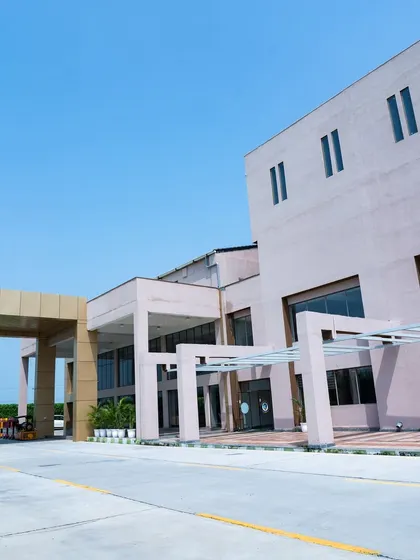 The main facade of Konark Academy, showcasing its modern, block-like forms and large glass windows. The design balances solid mass with transparent elements, creating a dynamic and contemporary architectural statement.