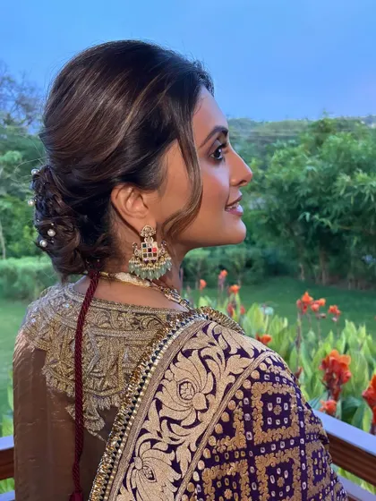 The side profile of this romantic updo shows the soft tendrils framing the face and the volume at the crown. This is a flattering style for many face shapes, and a go-to for wedding guests.