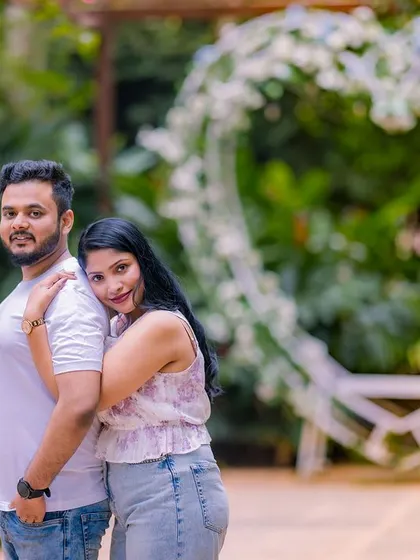 A relaxed and happy portrait in front of a heart-shaped arch. This photo captures the couple's easy chemistry in a casual and comfortable setting.
