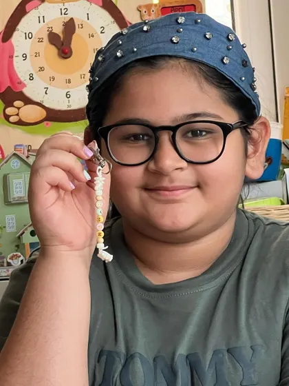 This young artist is all smiles with her finished dinosaur-themed keychain.