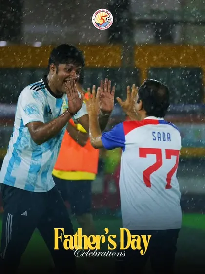 Two fathers sharing a high-five in the rain during our fun-filled Father's Day football event.