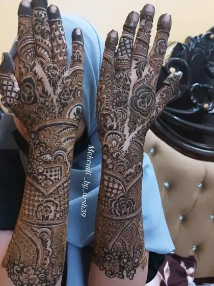 A close-up of the same bridal design, showing the patterns on the arms.