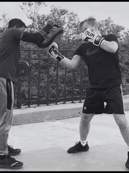 Consistency is key. This black and white shot captures the focus and intensity of a personal boxing session, where every punch is a step toward achieving your fitness goals.