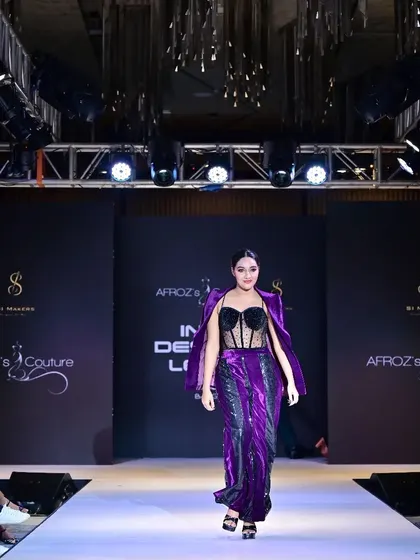 A look from one of my runway collections, this purple two-piece features a sequined corset top and a matching velvet pant set with an attached jacket. This design showcases my love for mixing textures and creating head-turning evening wear.