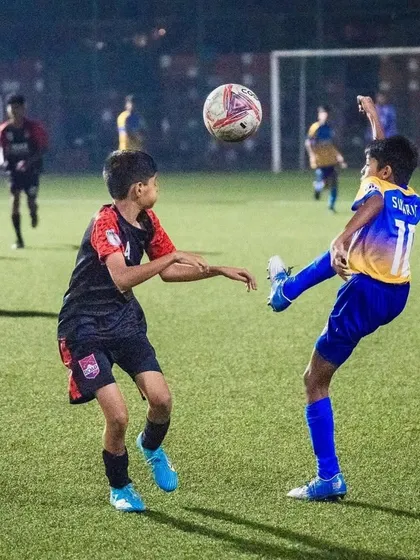 An aerial challenge between our player and an opponent during the U13 semi-final match.