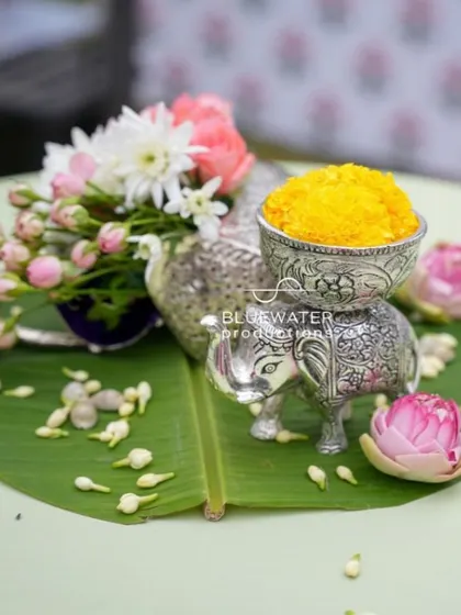 A silver elephant figurine holds a small bowl of turmeric, a beautiful and symbolic detail for a Haldi ceremony.
