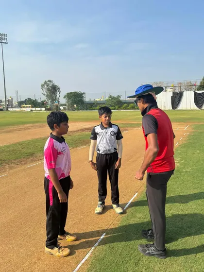 A coach mediates the pre-match discussion between two young captains, fostering sportsmanship and fair play.