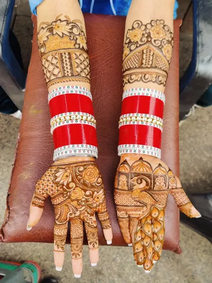 A classic bridal look with peacock and floral mehandi paired with the traditional red chooda bangles.
