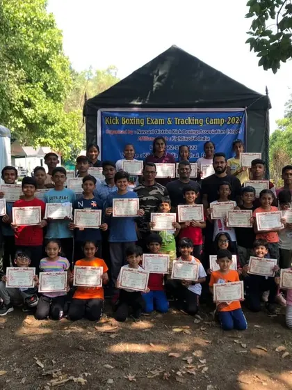 A large group of young students with their certificates after a kickboxing yellow belt exam and tracking camp for our Navsari branch.
