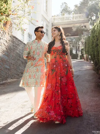 A happy, sun-drenched shot of the couple walking down a charming street in Mussoorie, their colorful outfits shining in the light.