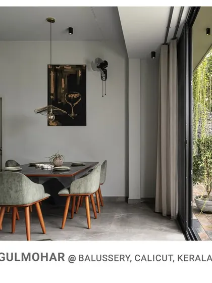 The dining area at Gulmohar is positioned next to a large glass door, providing diners with a beautiful view of the garden and the cascading curtain creepers.