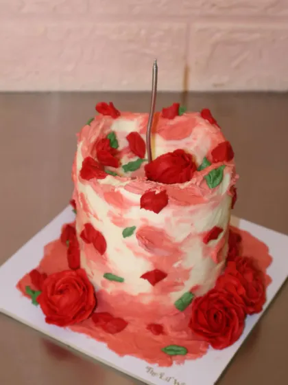 A mini cake that’s big on romance. This tall, single-serving cake is decorated with abstract red and pink buttercream strokes and topped with handcrafted red sugar roses.