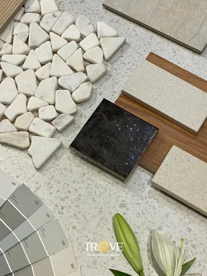 A beautiful mood board showcasing a mix of textures and neutral tones. It combines pebble mosaics, wood grain, and terrazzo look tiles with a coordinating color palette to create a serene and sophisticated design concept.