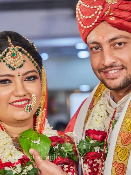 A lovely posed portrait of the couple during their ceremony. They are looking directly at the camera, showcasing their happiness and traditional wedding look.