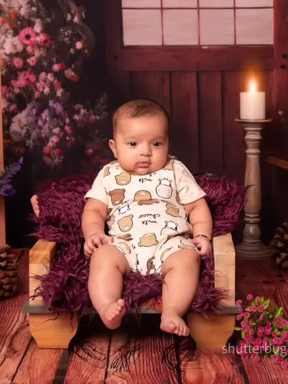 A serious and sweet portrait of a three-month-old baby sitting patiently for her photo in our rustic floral set.