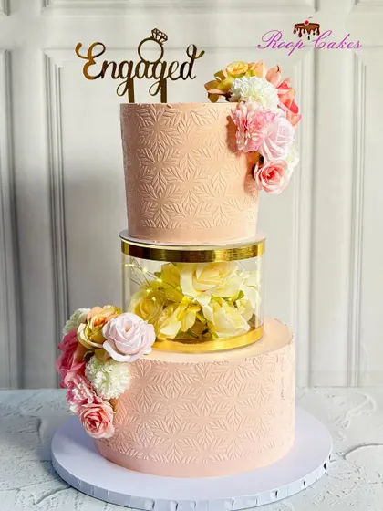 Where elegance meets sweetness. This stunning engagement cake with a floral separator and delicate stenciling is one of my most requested designs, perfect for celebrating love.