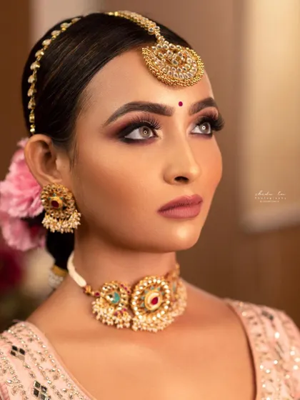 This lightweight choker set with Meenakari details is a great rental option for pre-wedding events like Haldi or Mehendi. The simple maang tikka and matching earrings complete the look without being overpowering.