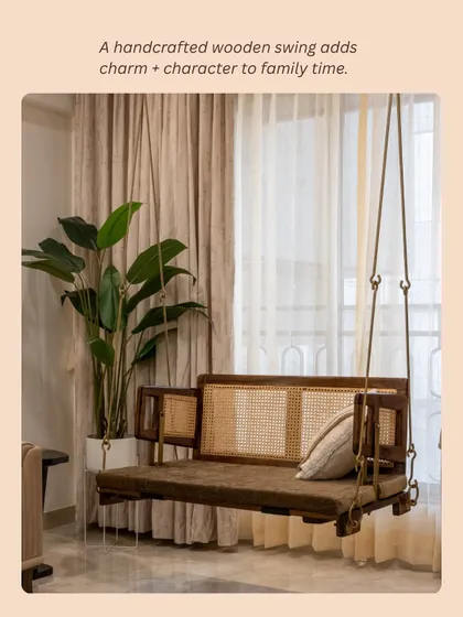 A handcrafted wooden swing with cane webbing adds charm and character to family time in this living room, blending modern simplicity with Indian soul.