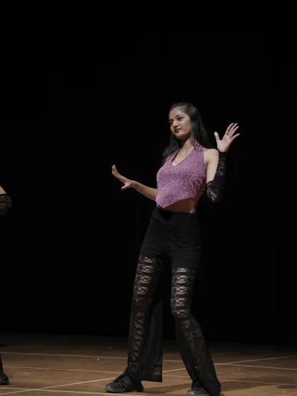 A young performer from the 'Sassy Girls' group, owning her space on the big stage.