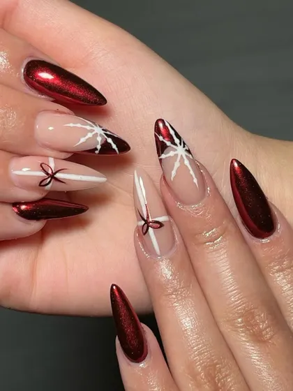 All wrapped up for the holidays. This festive set combines a stunning red chrome with accent nails featuring hand-painted bows and stars.