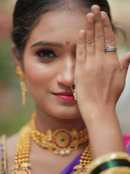 A close-up of a classic Maharashtrian look, focusing on the details. The expressive eyes, the traditional nath, and the perfectly matched gold jewelry come together to create timeless elegance.